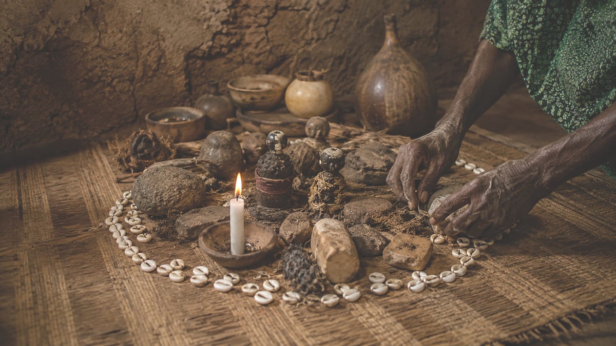 Cercle de cauris et bougie allumée sur une natte, rituel de retour affectif